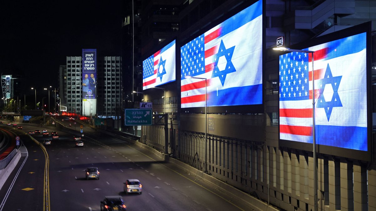 Traffic moves past the giant screens installed along the highway displaying the national flags of the U.S. and Israel, Tel Aviv, Israel, March 4, 2026. (AFP Photo)