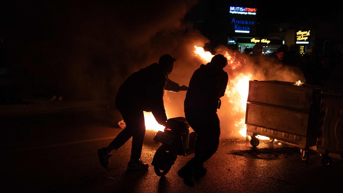 Rioters push a scooter into a barricade fire, Izmir, western Türkiye, March 21, 2025. (AFP Photo)
