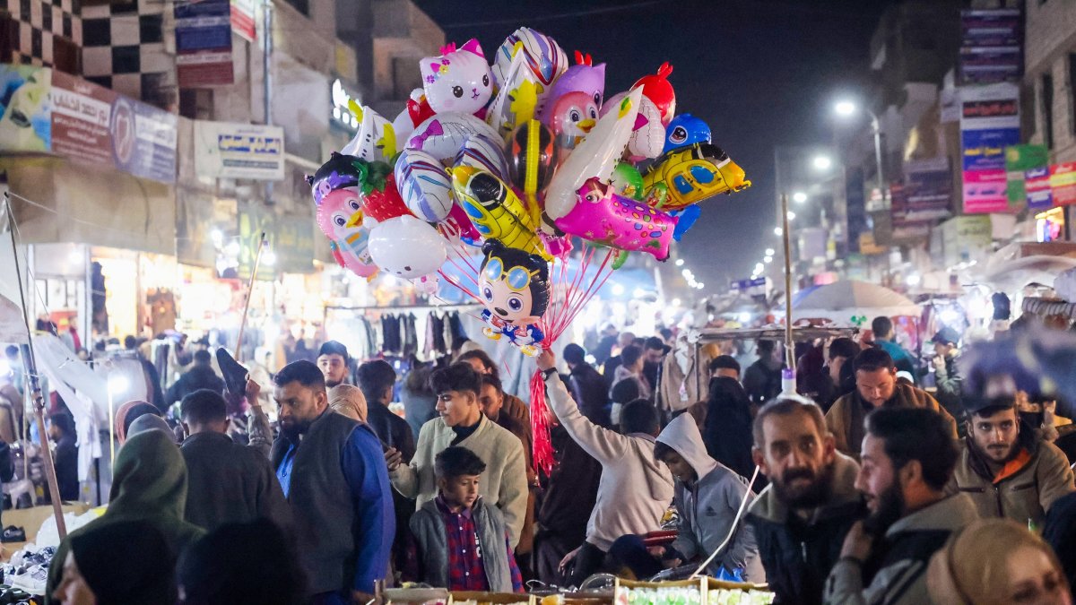 A seller displays balloons as people shop at a market, Raqqa, Syria, April 11, 2025. (AA Photo)