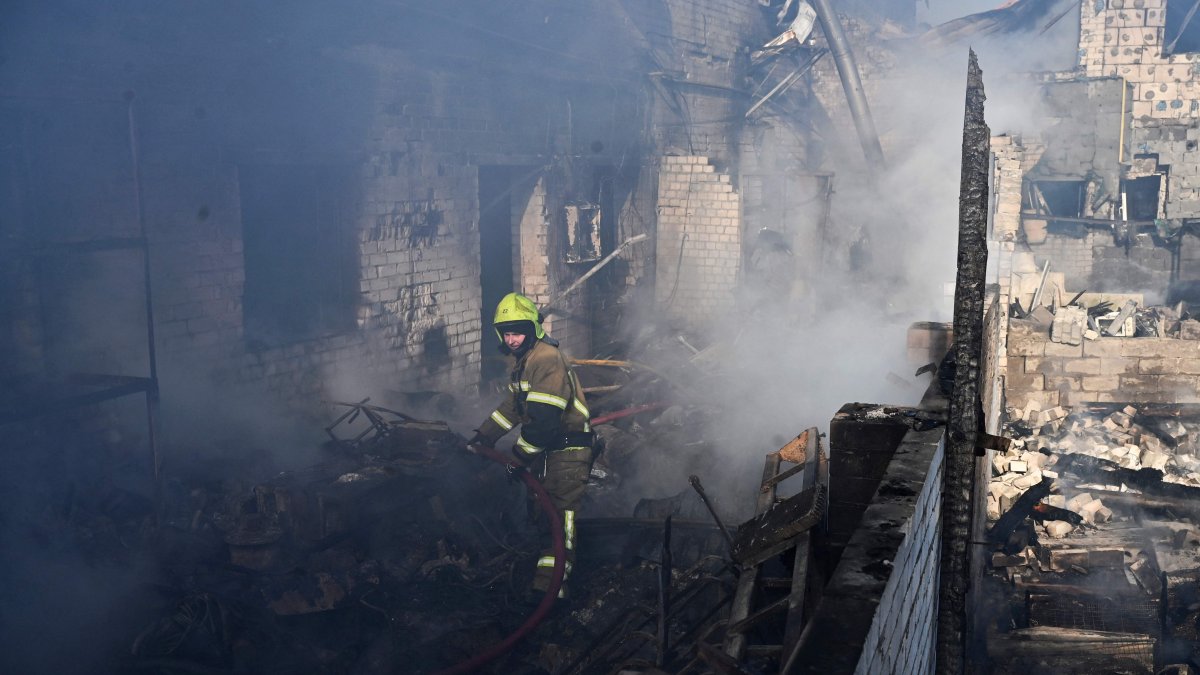 A firefighter extinguishes a fire at a site of a strike in the town of Brovary, near Kyiv, following a Russian missile and drone attack, March 14, 2026. (AFP Photo)