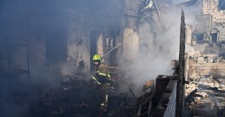 A firefighter extinguishes a fire at a site of a strike in the town of Brovary, near Kyiv, following a Russian missile and drone attack, March 14, 2026. (AFP Photo)