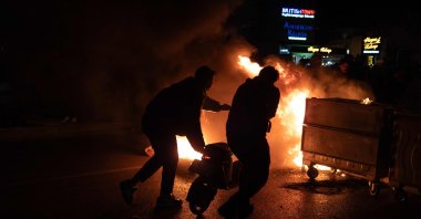 Rioters push a scooter into a barricade fire, Izmir, western Türkiye, March 21, 2025. (AFP Photo)
