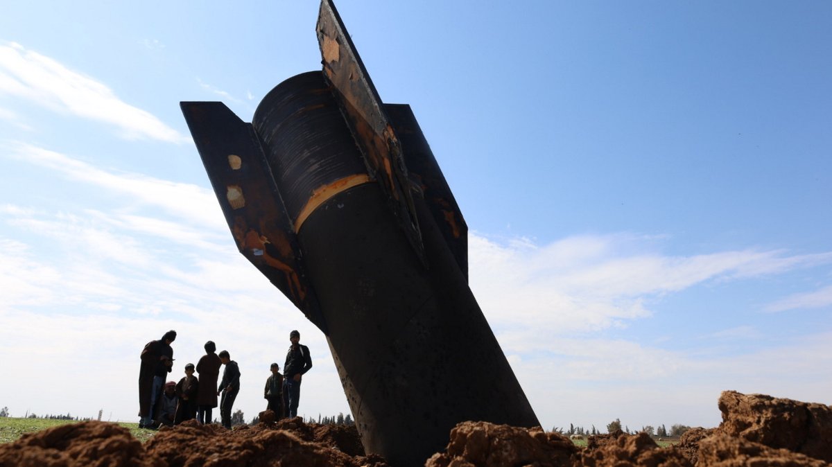People stand next to an Iranian missile launched in retaliation against U.S. bases in nearby countries, the village of Qazaljo, Qamishli countryside, Syria, March 4, 2026.