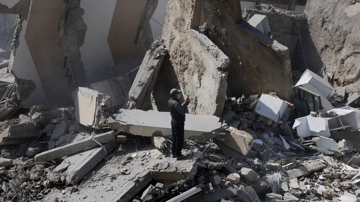 A man uses a phone while standing amid debris at the site of an Israeli strike, Zuqaq al-Blat district in central Beirut, Lebanon, March 18, 2026. (Reuters Photo)