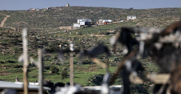 An Israeli outpost is pictured through a burnt lorry that was set on fire by illegal Israeli settlers from a nearby settlement, in Susya village, south of Hebron in the Israeli-occupied West Bank, Palestine, Feb. 25, 2026. (AFP Photo)
