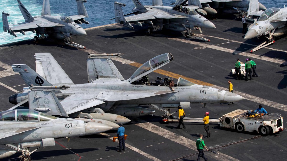 U.S. sailors taxi an F/A-18F Super Hornet, attached to Strike Fighter Squadron (VFA) 41, on the flight deck aboard Nimitz-class aircraft carrier USS Abraham Lincoln (CVN 72), in support of Operation Epic Fury, March 17, 2026. (AFP Photo)