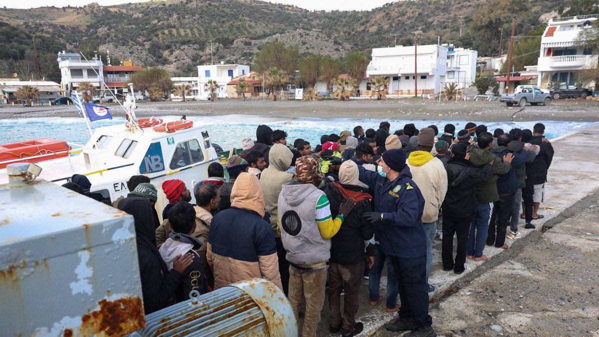 Migrants stand in line as a Greek coast guard officer counts them at the port of Kaloi Limenes, on the island of Crete, Greece, Feb. 21, 2026. (Reuters Photo)