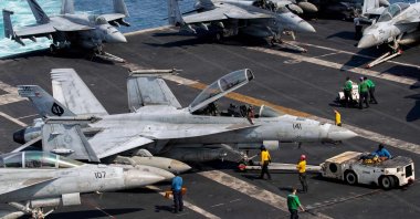U.S. sailors taxi an F/A-18F Super Hornet, attached to Strike Fighter Squadron (VFA) 41, on the flight deck aboard Nimitz-class aircraft carrier USS Abraham Lincoln (CVN 72), in support of Operation Epic Fury, March 17, 2026. (AFP Photo)