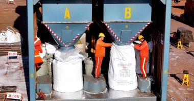 Fertilizer is bagged after being unloaded from a ship at the port, Lianyungang, China, March 19, 2026. (AFP Photo)