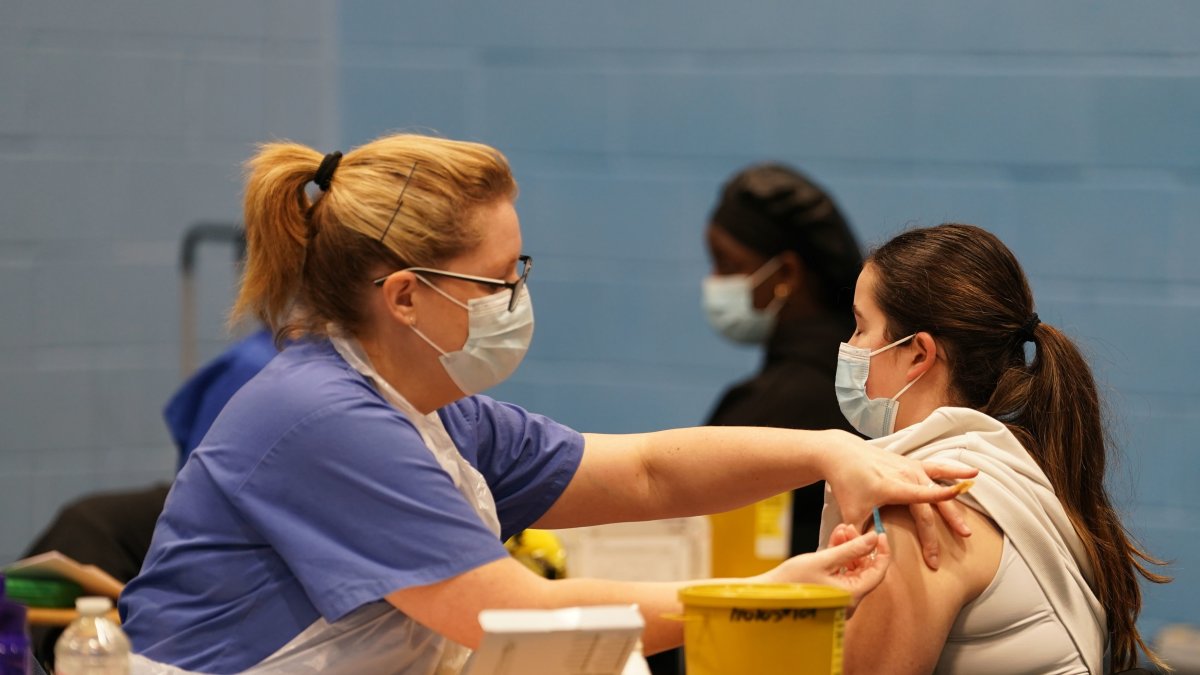 A student receives an injection from medical staff in the sports hall at the University of Kent campus, Canterbury, U.K., March 19, 2026. (AP Photo)
