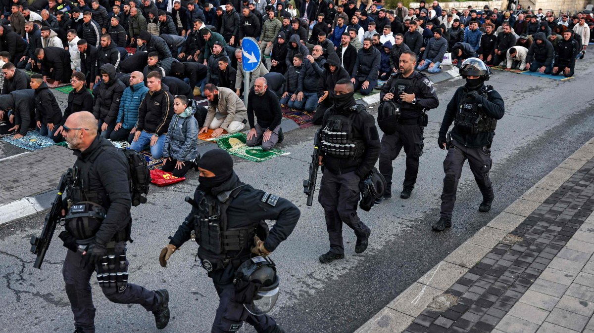 Israeli security forces walk past Muslim worshippers gathering outside the city walls of, Jerusalem, Palestine, March 20, 2026. (AFP Photo) 