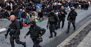 Israeli security forces walk past Muslim worshippers gathering outside the city walls of, Jerusalem, Palestine, March 20, 2026. (AFP Photo) 