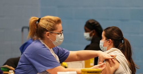 A student receives an injection from medical staff in the sports hall at the University of Kent campus, Canterbury, U.K., March 19, 2026. (AP Photo)