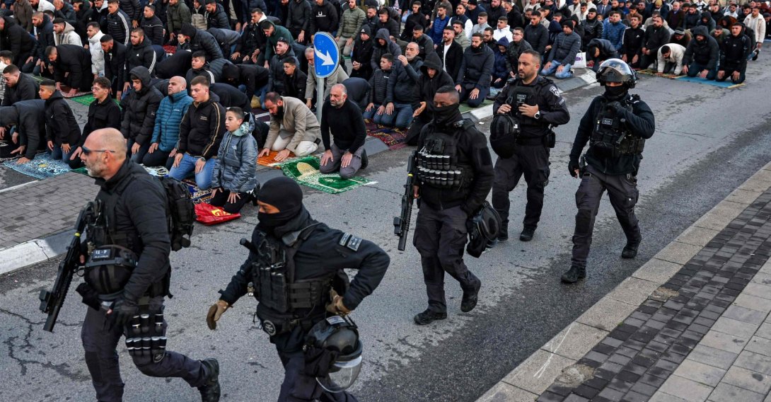 Israeli security forces walk past Muslim worshippers gathering outside the city walls of, Jerusalem, Palestine, March 20, 2026. (AFP Photo) 