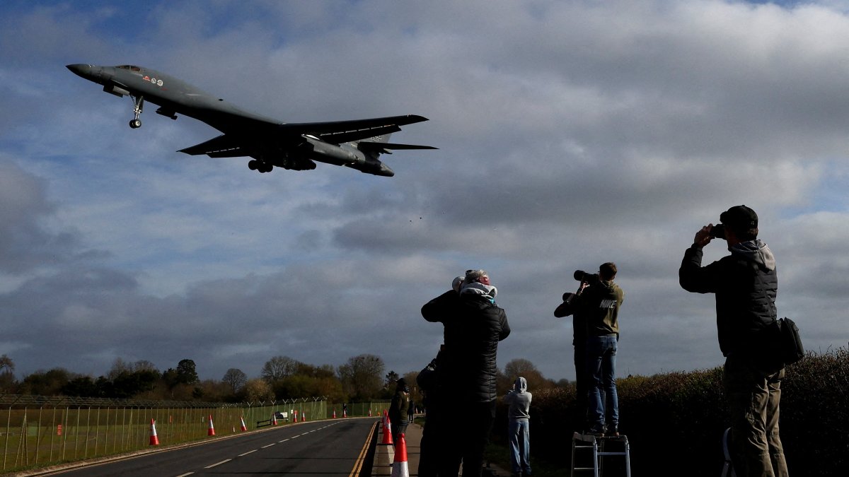 People use their cameras as a USAF B-1 bomber approaches to land at RAF Fairford airbase, used by United States Air Force (USAF) personnel, amid the U.S.-Israeli conflict with Iran, Fairford, U.K., March 17, 2026. (Reuters Photo)