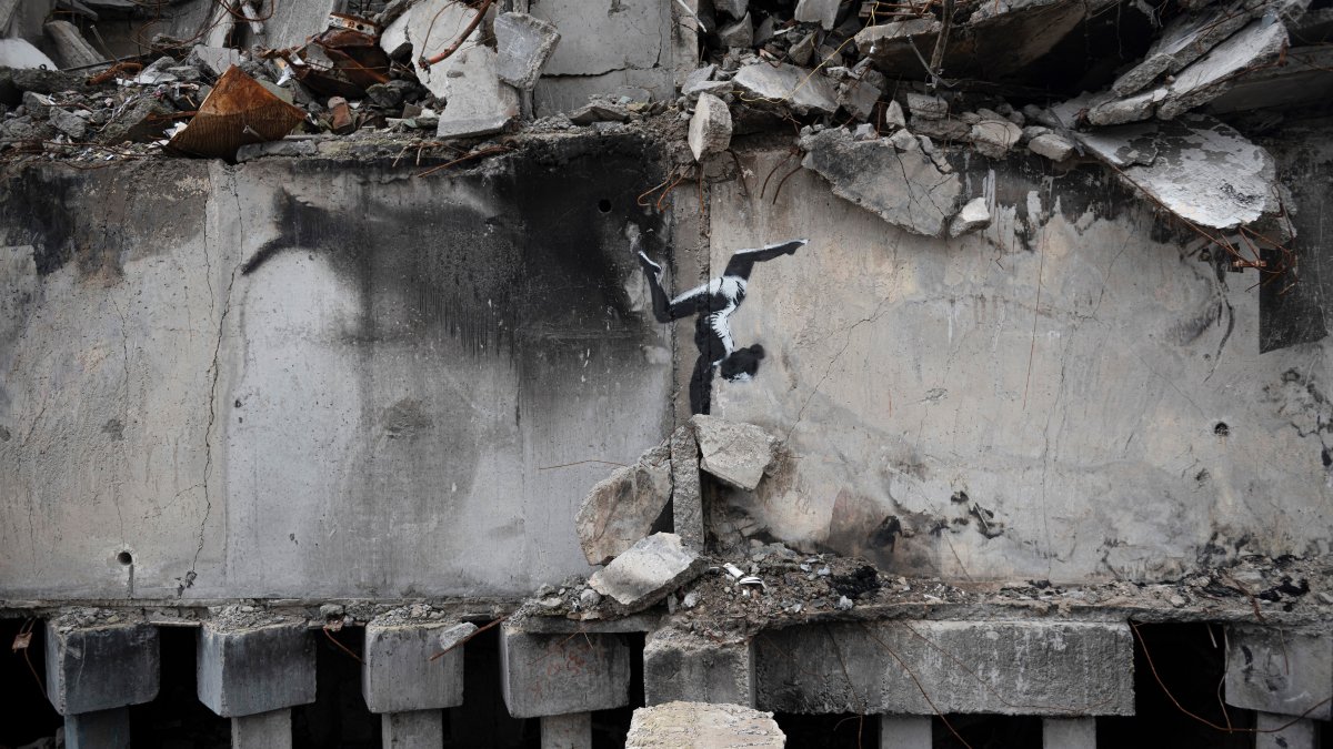 A painting by British street artist Banksy is seen on a building destroyed by fighting in Borodyanka, Kyiv region, Ukraine, Nov. 13, 2022. (AP Photo)