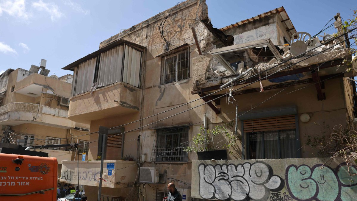 Rescuers secure the area around a house damaged following an impact reportedly caused either by a missile or by interceptor fragments, Tel Aviv, Israel, March 22, 2026. (AFP Photo)