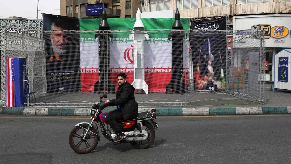 A motorist rides past the dummy models of Iranian missiles installed along the roadside at the Valiasr Square, in Tehran, Iran, March 22, 2026. (AFP Photo)