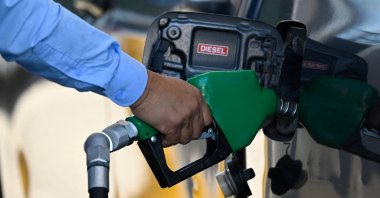 A man holds a fuel pump at a gas station in Guatemala City, Guatemala, March 10, 2026. (AFP Photo)