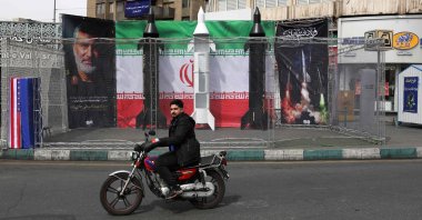 A motorist rides past the dummy models of Iranian missiles installed along the roadside at the Valiasr Square, in Tehran, Iran, March 22, 2026. (AFP Photo)