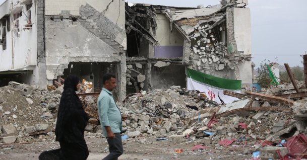 Iranians walk past the destroyed Shajareh Tayyebeh elementary school, where a suspected U.S. strike killed 185 people on Feb. 28, in the southern city of Minab, Iran, March 21, 2026. (AA Photo)