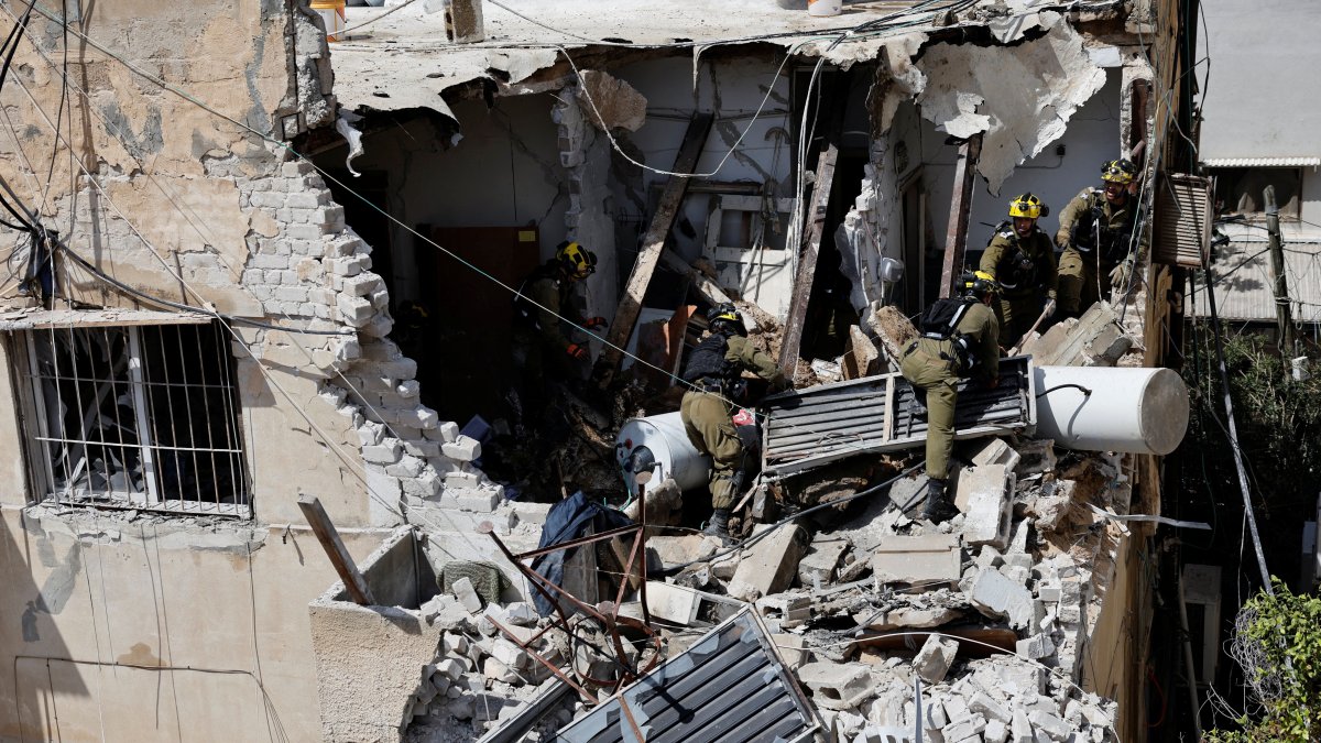 Israeli soldiers inspect the site of a damaged building following barrages of Iranian missiles, amid the U.S.-Israeli conflict with Iran, in Tel Aviv, Israel, March 22, 2026. (Reuters Photo)
