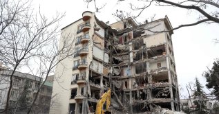 Iranian firefighters with the help of an excavator clear rubble from a destroyed residential building in northern Tehran, Iran, March 23, 2026. (AFP Photo) 