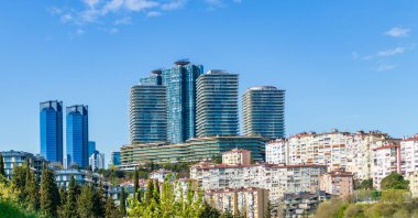 Modern residential and business towers rise above traditional housing in Istanbul, Türkiye, March 31, 2025. (Shutterstock Photo) 