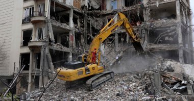 Iranian firefighters use an excavator to clear rubble from a residential building destroyed by an Israeli airstrike, Tehran, Iran, March 23, 2026. (AFP Photo)