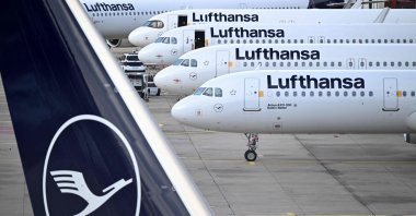 The logo of German airline Lufthansa is seen on the vertical stabiliser and aircraft parked on the tarmac at the international Frankfurt Airport, Frankfurt am Main, western Germany, March 12, 2026. (AFP File Photo)