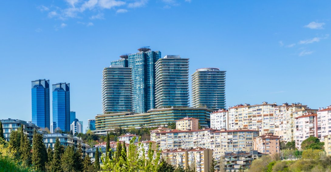Modern residential and business towers rise above traditional housing in Istanbul, Türkiye, March 31, 2025. (Shutterstock Photo) 