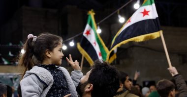 A girl shows a peace sign as Syrians gather to mark the anniversary of the 2011 uprising that ousted the Assad regime, Damascus, Syria, March 15, 2026. (Reuters photo)
