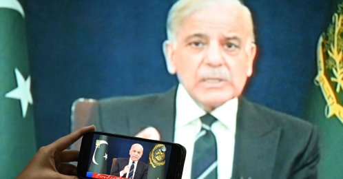 A resident listens on a mobile phone to an address to the nation by Pakistan’s Prime Minister Shehbaz Sharif, in Islamabad, March 9, 2026. (AFP Photo)