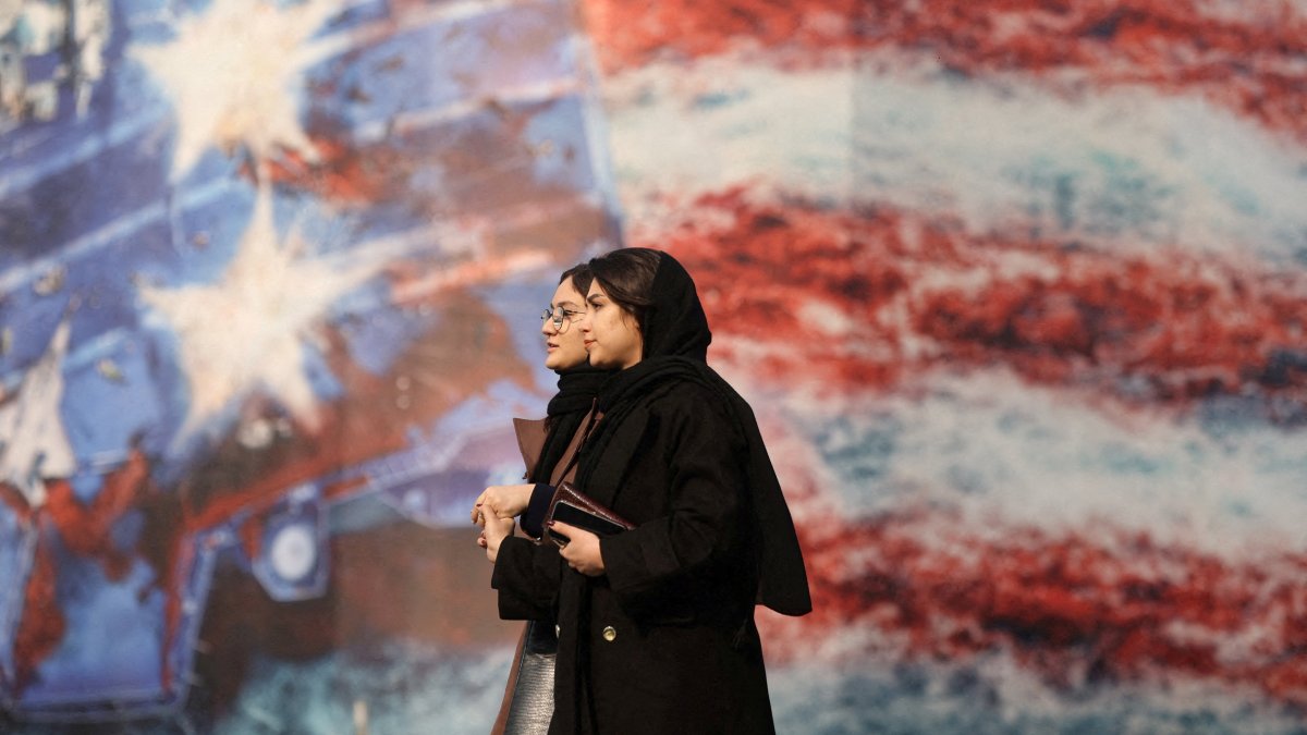 People walk past an anti-U.S. billboard in Tehran, Iran, Jan. 26, 2026. (Reuters Photo)