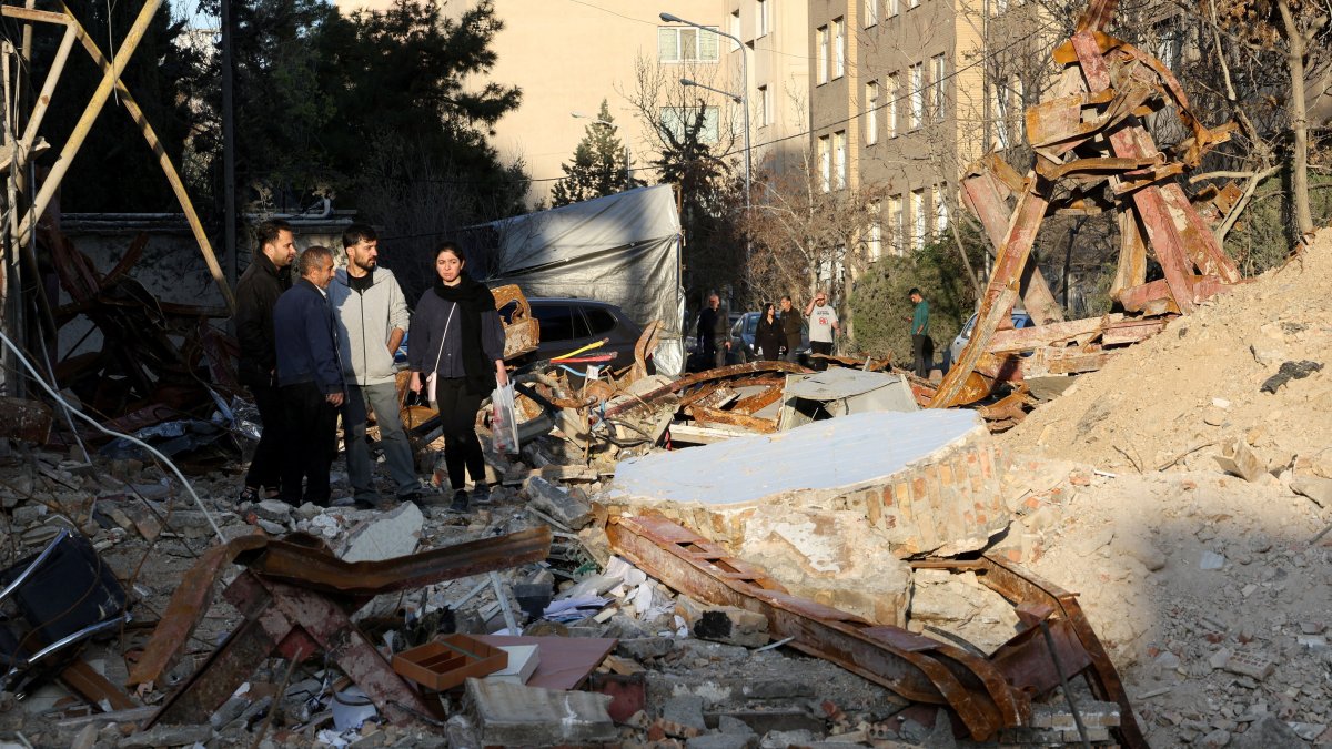 People look at a destroyed building following a strike, amid the U.S.-Israel-Iran war, Tehran, Iran, March 21, 2026. (Reuters Photo)
