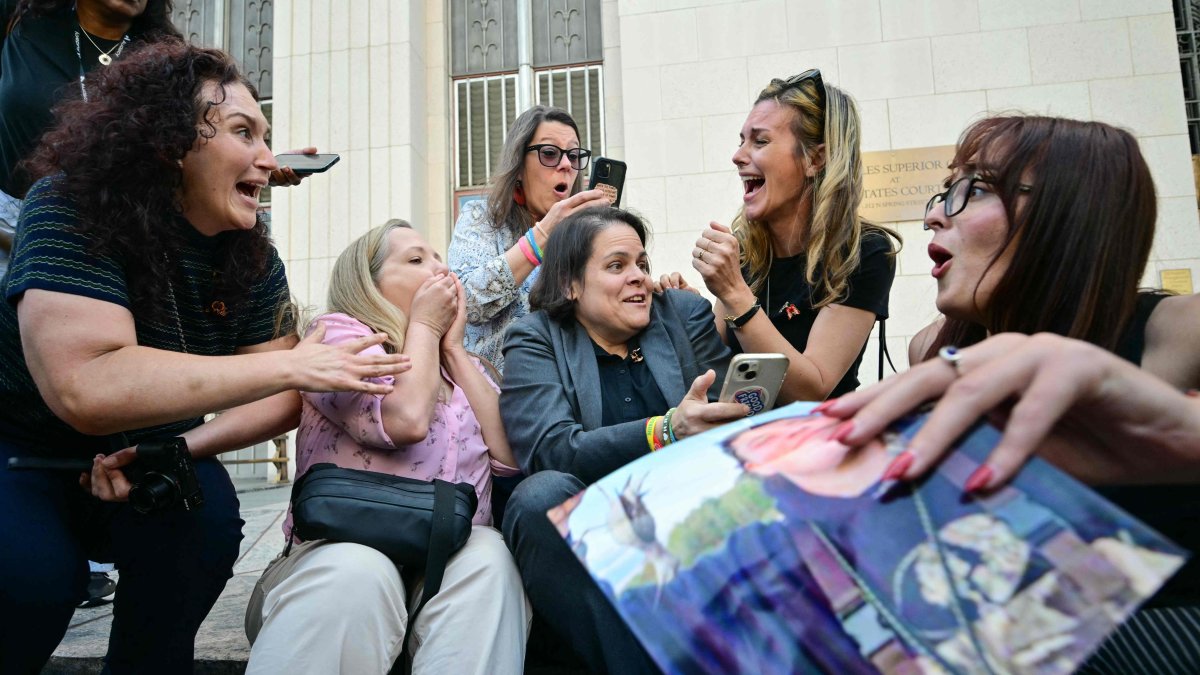 Laura Marquez-Garrett, plaintiffs' attorney for SMVLC (Social Media Victims Law Center), gathers with family members of victims as they react to news that the jury has found Meta and YouTube liable in the social media addiction trial, outside the Los Angeles Superior Court, in Los Angeles, March 25, 2026. (AFP Photo)