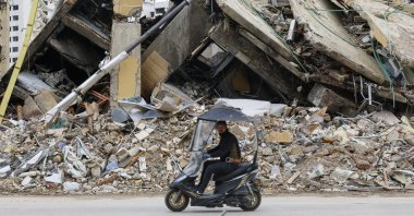 A man rides a scooter past the rubble of a building destroyed in an Israeli airstrike, southern Beirut, Lebanon, March 25, 2026. (EPA Photo)