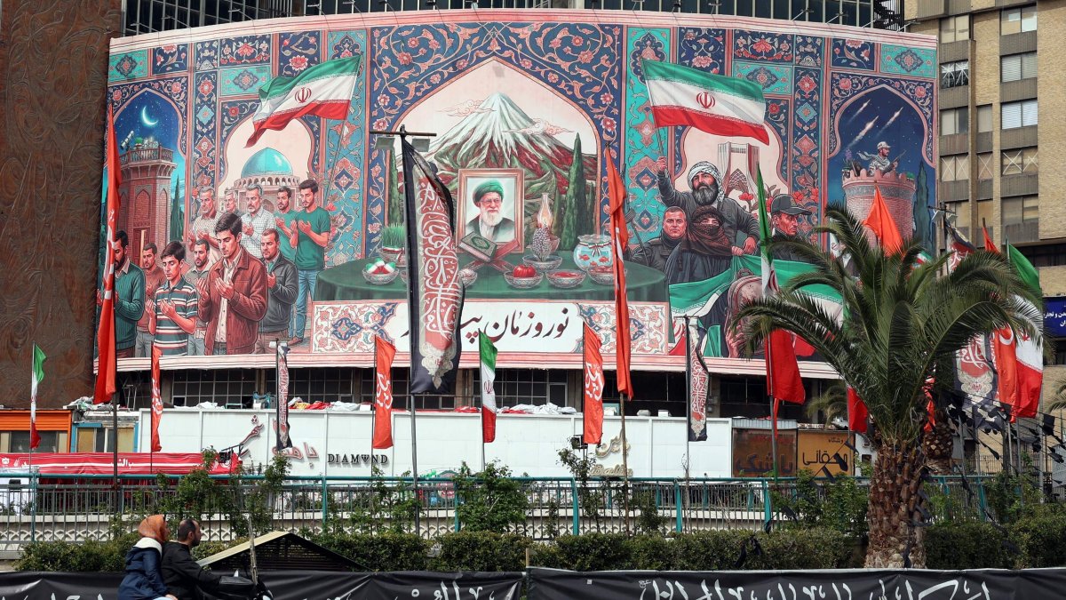 Motorists drive past a giant billboard with a portrait of Iran's slain Supreme Leader Ayatollah Ali Khamenei (C) at Valiasr Square, Tehran, Iran, March 22, 2026. (AFP Photo)
