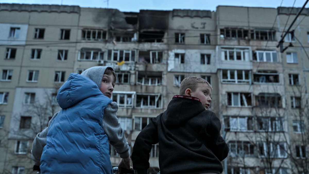 Boys on bicycles stand at the site of an apartment building hit by a Russian drone strike, central Lviv, Ukraine, March 24, 2026. (Reuters Photo)