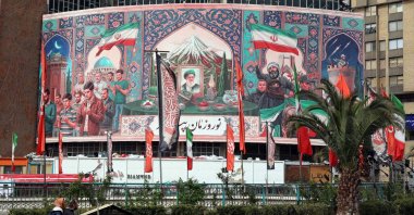 Motorists drive past a giant billboard with a portrait of Iran's slain Supreme Leader Ayatollah Ali Khamenei (C) at Valiasr Square, Tehran, Iran, March 22, 2026. (AFP Photo)