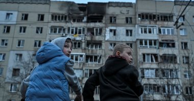 Boys on bicycles stand at the site of an apartment building hit by a Russian drone strike, central Lviv, Ukraine, March 24, 2026. (Reuters Photo)