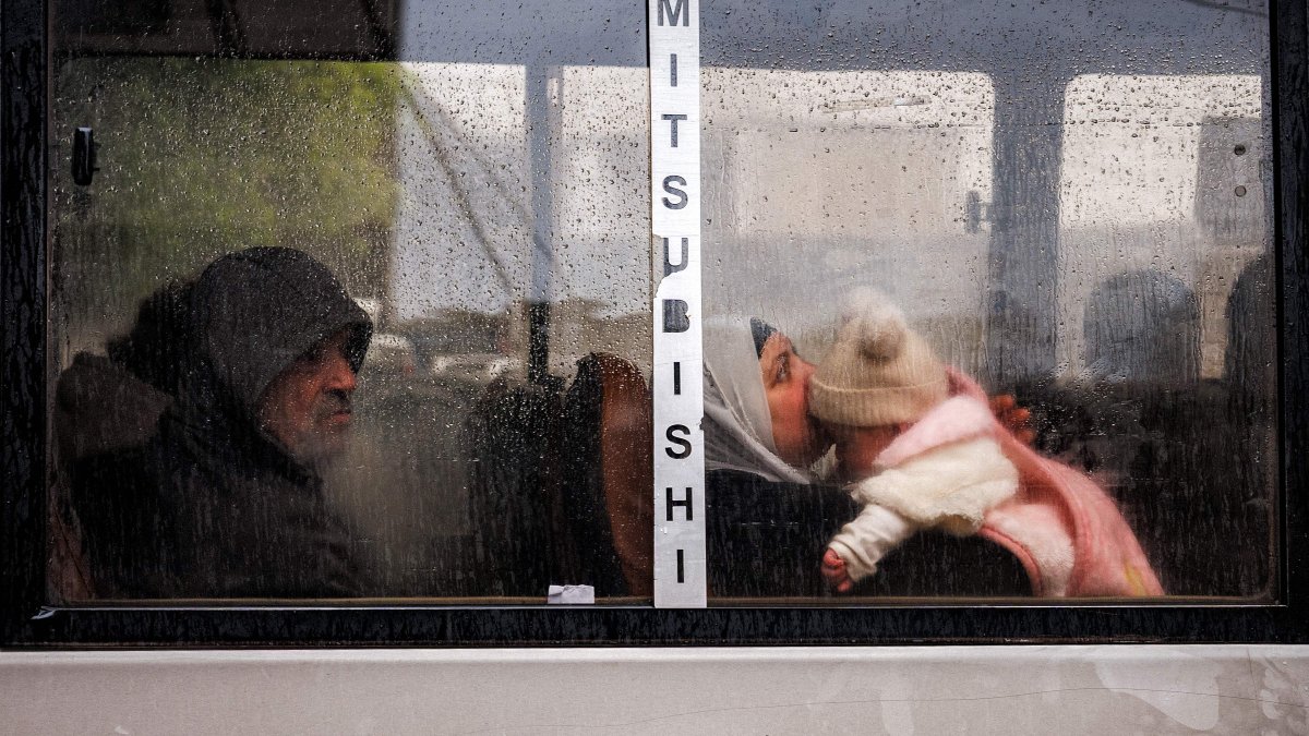 A woman holds a child as she rides in a bus during rain amid Israeli attacks, in central Beirut, Lebanon, March 26, 2026. (AFP Photo)