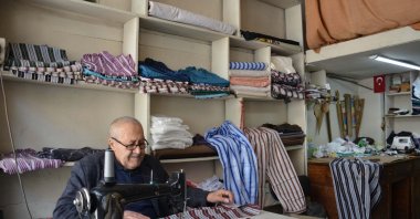 Yaşar Öztemel handcrafts nostalgic striped pajamas in his shop, Manisa, Türkiye, March 27, 2026. (DHA Photo)