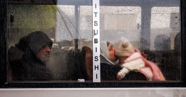 A woman holds a child as she rides in a bus during rain amid Israeli attacks, in central Beirut, Lebanon, March 26, 2026. (AFP Photo)