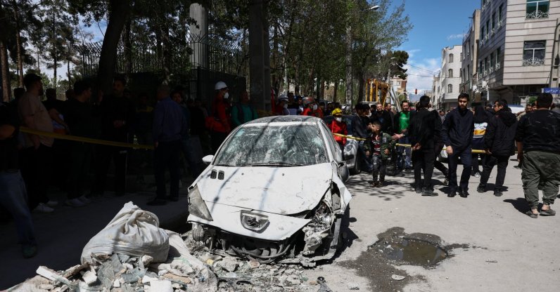 People gather near a damaged car at the site of a residential building damaged by a strike, amid the U.S.-Israeli conflict with Iran, in Tehran, Iran, March 27, 2026. (Reuters Photo)