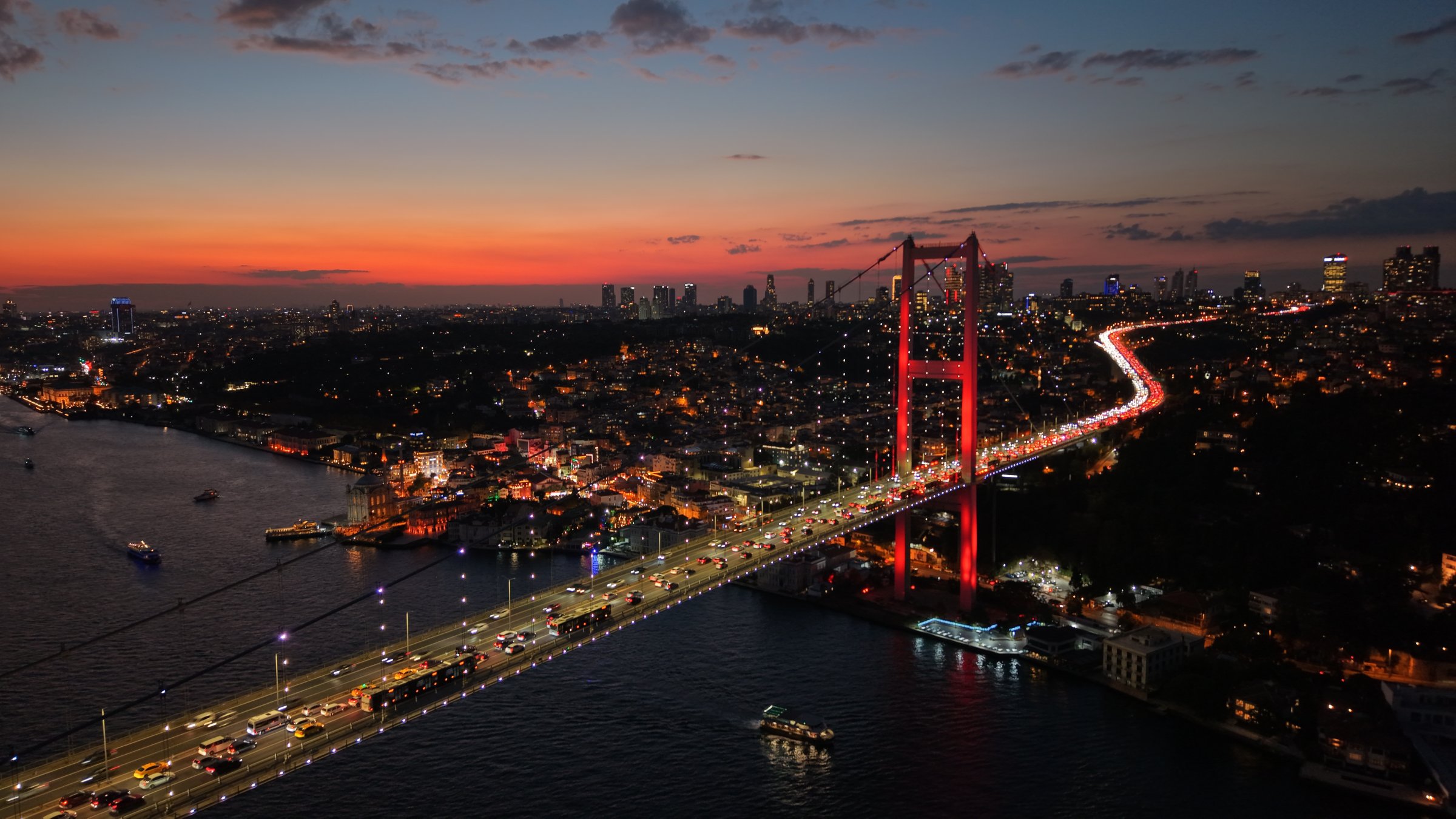 The Bosporus Bridge glows red at night as traffic flows beneath Istanbul’s skyline, Istanbul, Türkiye, Oct. 1, 2026. (Shutterstock Photo)