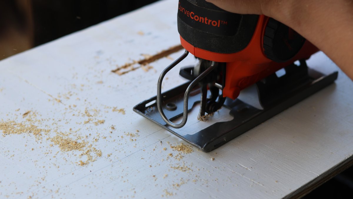 Felicia Fonseca uses a jigsaw to cut slits into a piece of plywood for a wedding sign at a do-it-yourself party at an apartment in Flagstaff, Ariz., U.S., Feb. 15, 2026. (AP Photo)