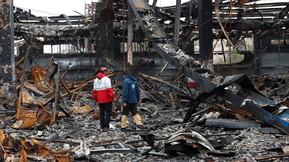 Members of the Iranian Red Crescent stand amid the wreckage of vehicles at an auto service center, Tehran, Iran, March 28, 2026. (EPA Photo)