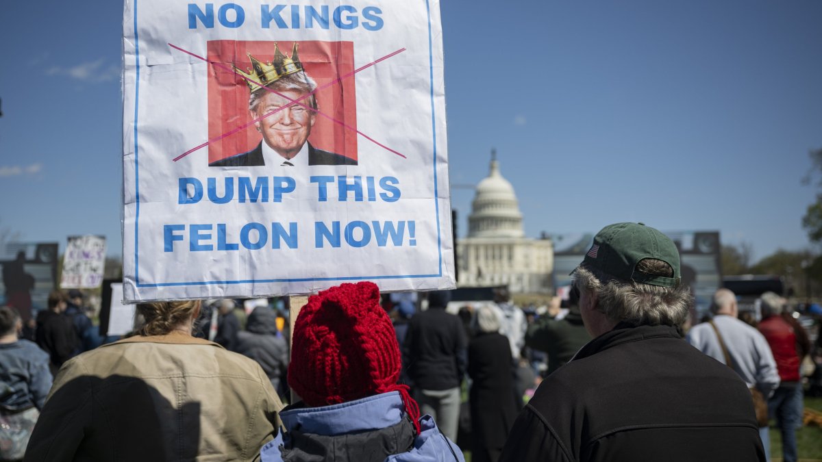 People hold signs during a national "No Kings" protest against President Donald Trump, Washington, D.C., U.S., March 28, 2026.