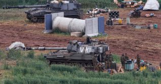 Israeli army soldiers stand next to a self-propelled Howitzer artillery gun positioned in the upper Galilee in northern Israel near the border with southern Lebanon, March 29, 2026. (AFP Photo)